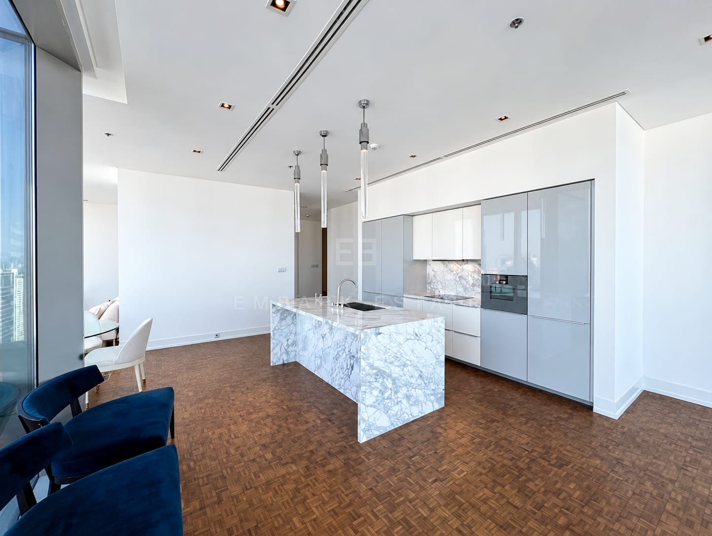 The Ritz-Carlton Residences Bangkok — open living room and kitchen with marble island and pendant lighting