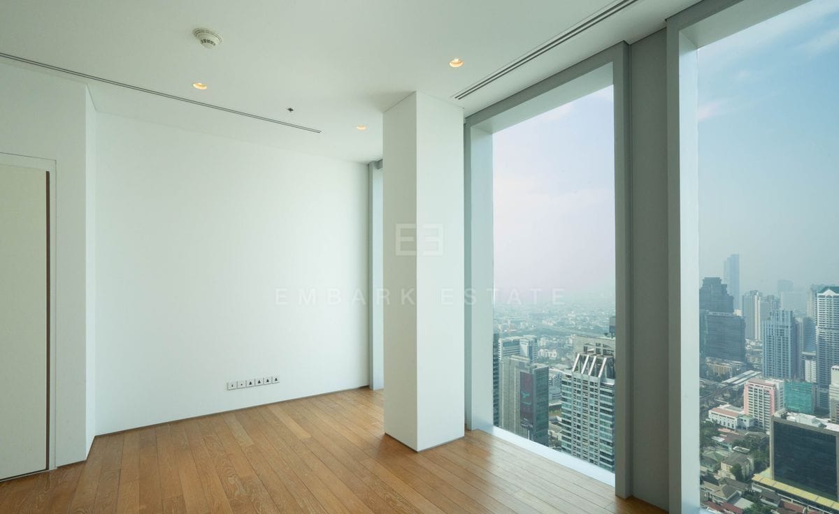 An upper room of the duplex residence at The Ritz-Carlton Residences Bangkok, oak floors and a full-height window over the city
