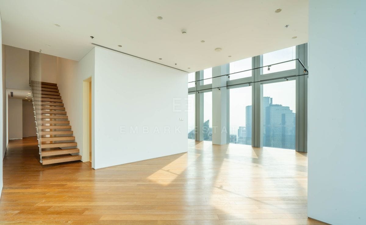 The double-height living space of the duplex, the floating oak staircase to one side