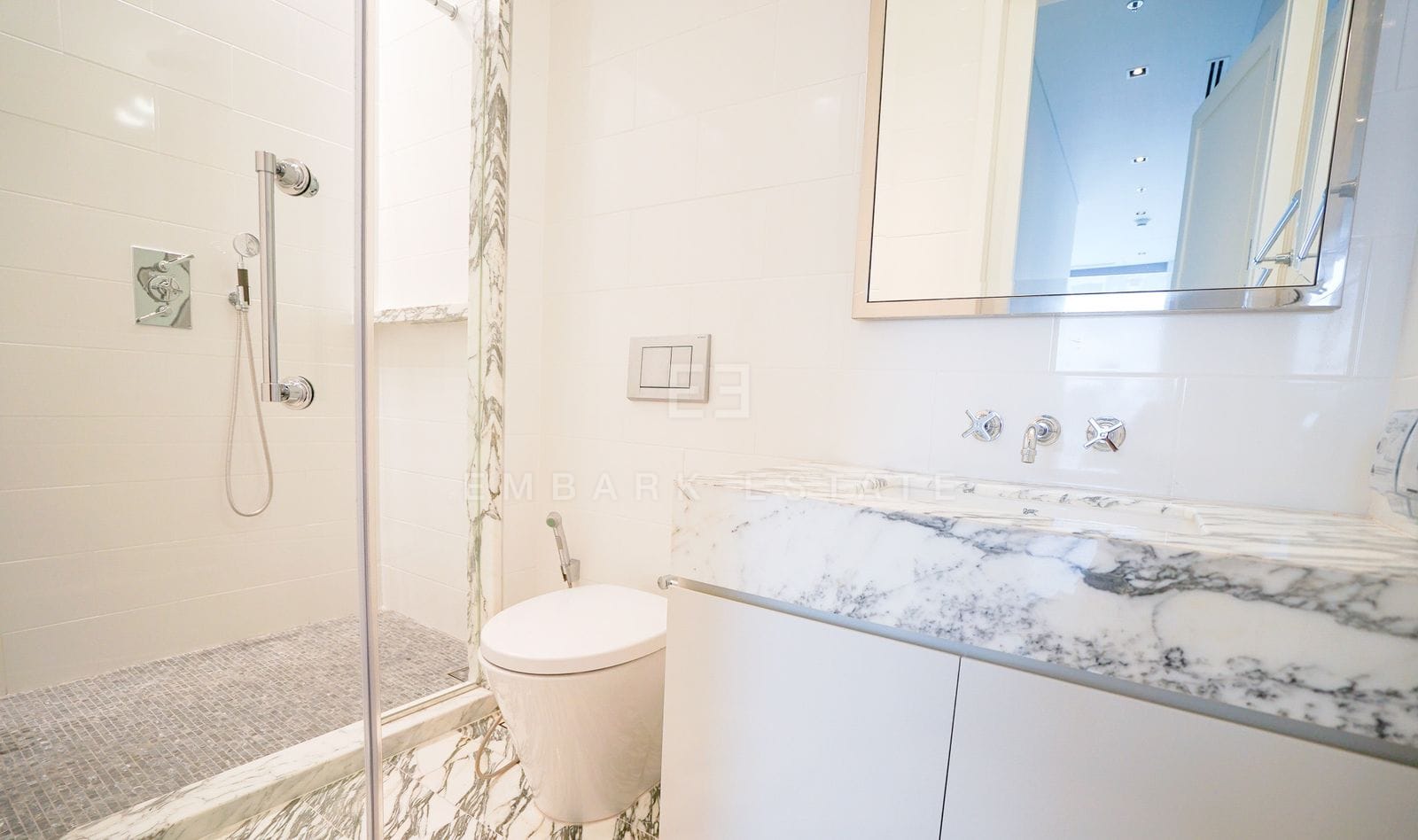 A bathroom of the 228 sq.m residence at The Ritz-Carlton Residences Bangkok, walk-in rain shower, WC and an Arabescato marble vanity