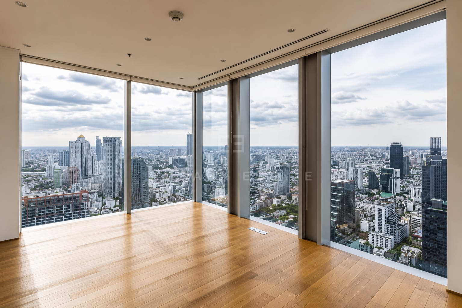 The corner of the living room at The Ritz-Carlton Residences Bangkok, the glazing turning the corner above central Bangkok