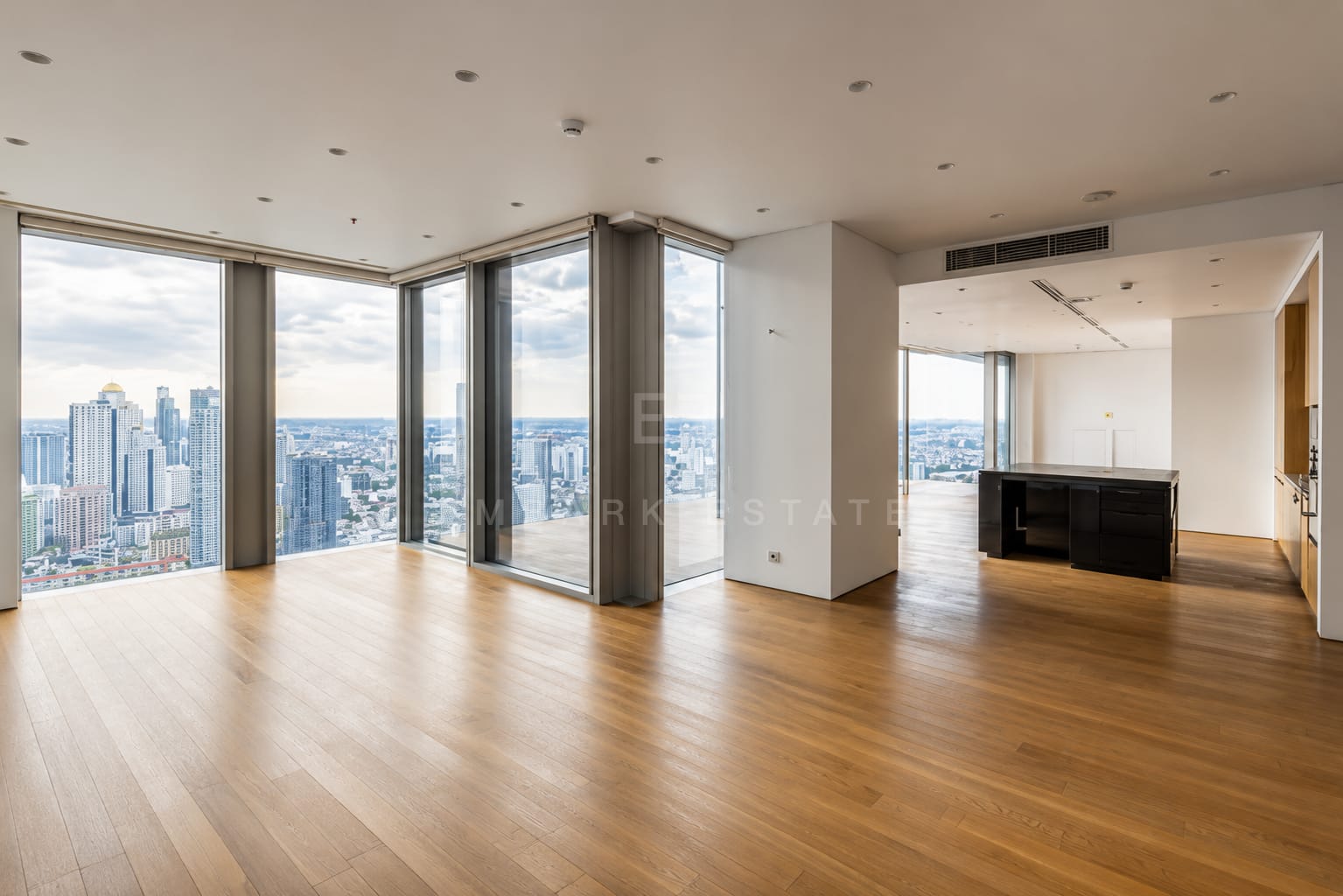 The living room at The Ritz-Carlton Residences Bangkok looking through to the kitchen counter, the residence photographed empty