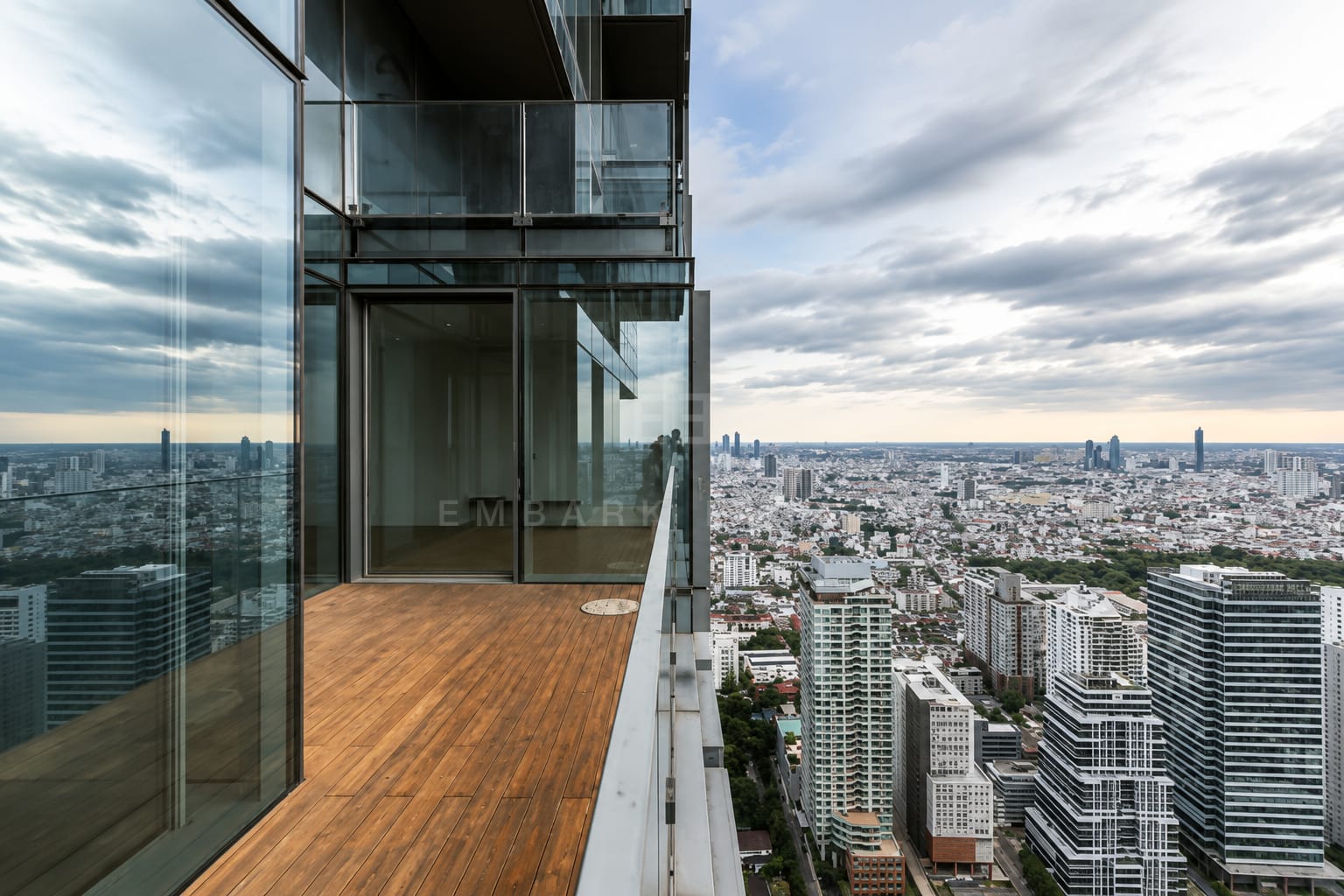 The terrace at The Ritz-Carlton Residences Bangkok running along the glazing, the tower's glass wall to one side and the city below