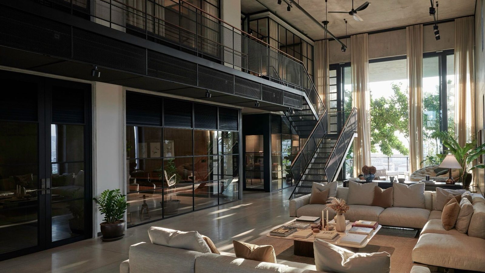Windshell Naradhiwas duplex show unit double-height living room with a floating staircase